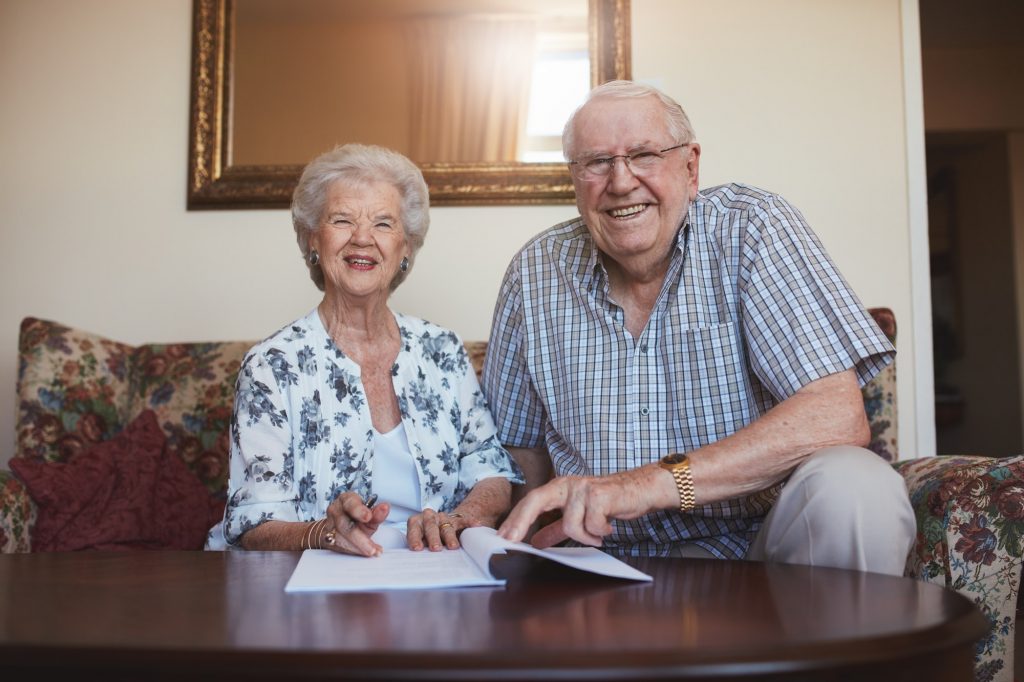 Smiling retired couple looking over documents