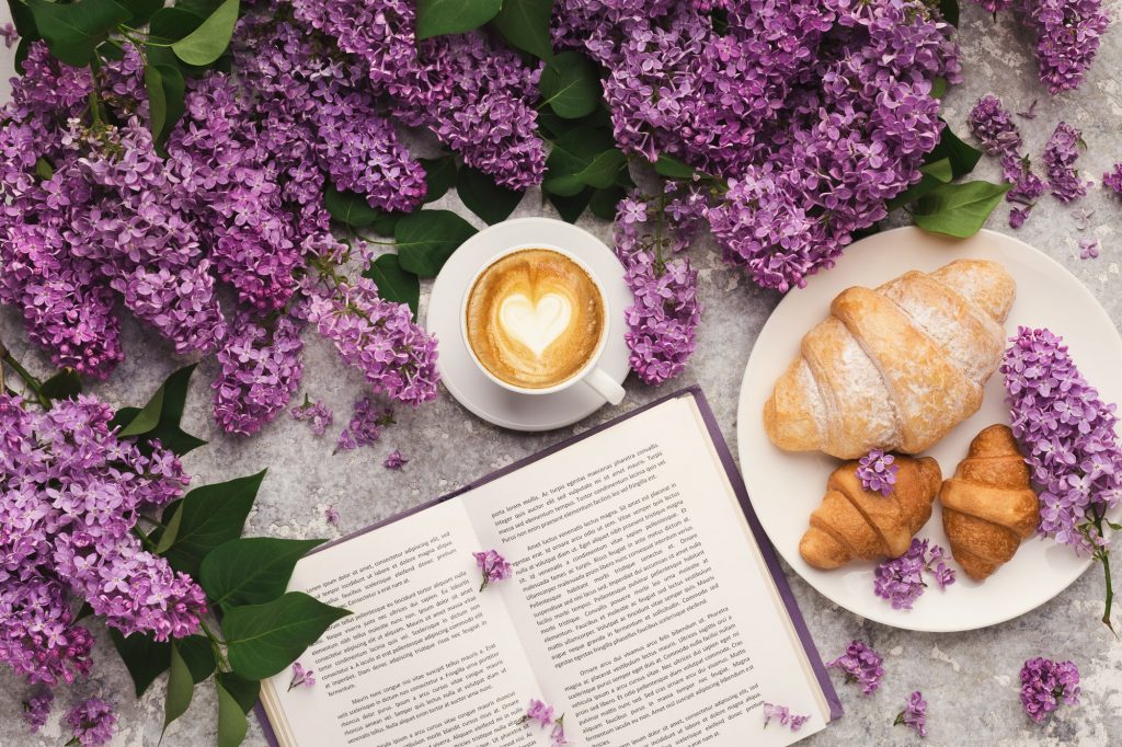 Spring background with lilac, coffee and book